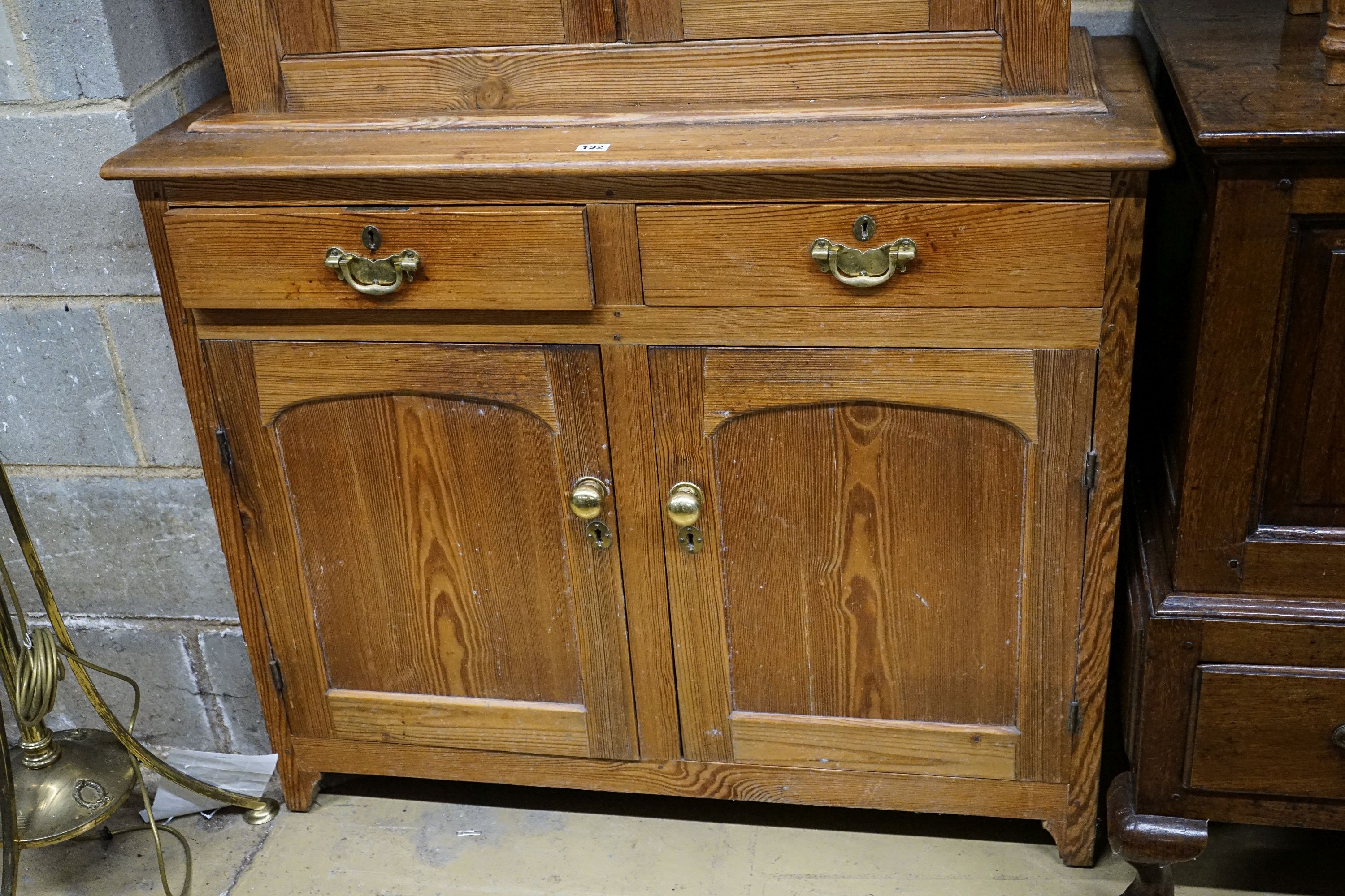 An Edwardian pine dresser, with two glazed doors over two drawers and panelled doors, width 107cm, depth 43cm, height 194cm